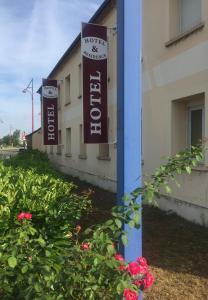 a row of signs on a building with flowers at Hôtel & Résidence Avermes in Avermes