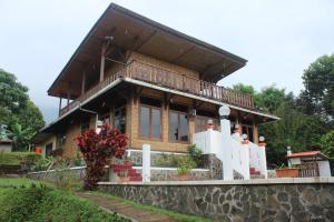 uma casa com uma varanda no topo de uma parede em Salak Sunrise Homestead em Bogor