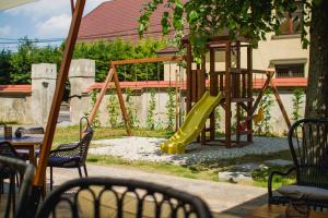 a playground with a yellow slide in a yard at Penzión Kúria in Nové Mesto nad Váhom