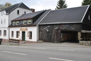 a large wooden building with a garage on a street at Waldhaus Crottendorf in Crottendorf