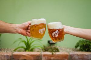 two people holdingints of beer in their hands at Penzión Kúria in Nové Mesto nad Váhom