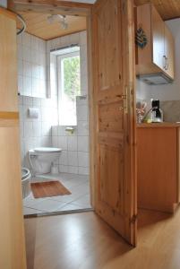 a bathroom with a toilet and a sink and a door at Waldhaus Crottendorf in Crottendorf