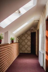 a hallway with a brick wall and a ceiling with skylights at Penzión Kúria in Nové Mesto nad Váhom
