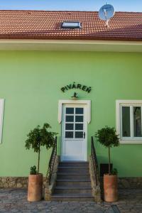 a green building with a white door and stairs at Penzión Kúria in Nové Mesto nad Váhom