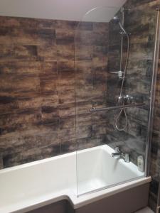 a bathroom with a bath tub and a sink at Pinetree Lodge Druridge Bay in Amble