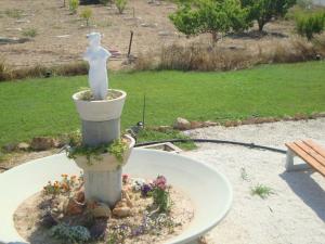 a statue of a woman sitting in a flower pot at Bella Rosa hotel Cyprus in Coral Bay