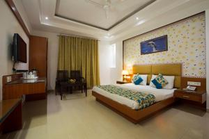 a hotel room with a bed and a television at Hotel Krishna Deluxe-By RCG Hotels in New Delhi