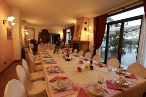a long dining room with a long table and chairs at Casa San Marco in Castelnuovo del Garda