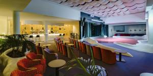 a lobby with chairs and tables and a bar at H10 Suites Lanzarote Gardens in Costa Teguise