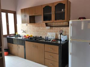 a kitchen with a black counter top and a white refrigerator at 1 BHK Deluxe Apartment in Candolim by GR Stays in Candolim