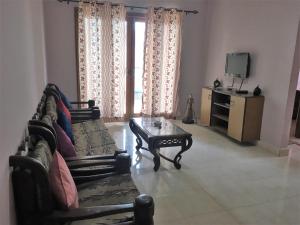 a living room with a couch and a coffee table at 1 BHK Deluxe Apartment in Candolim by GR Stays in Candolim