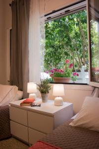 ハニア・タウンにあるAlexandra Apartment Near Chania Centerのベッドルーム1室(ベッド1台付)、花の咲く窓が備わります。