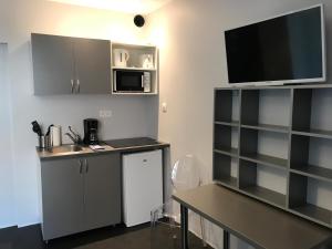 a kitchen with a sink and a tv on the wall at SmartAppart Troyes in Troyes