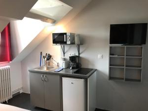 uma cozinha com um lavatório e uma televisão na parede em SmartAppart Troyes em Troyes