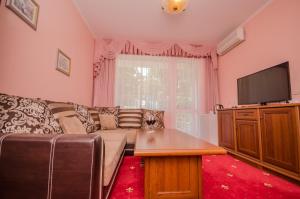 a living room with a couch and a flat screen tv at Mini Hotel Mechta in Utes