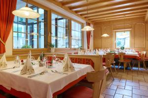 een eetkamer met tafels, stoelen en ramen bij Hotel Schwarzer Adler in Resia