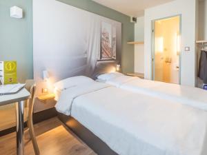 A bed or beds in a room at B&B HOTEL Strasbourg Sud Geispolsheim