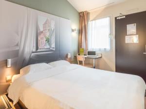 A bed or beds in a room at B&B HOTEL Strasbourg Sud Geispolsheim