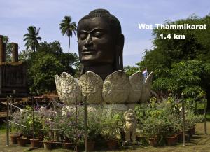 a statue of a head in a garden at Early Bird Hostel Ayutthaya in Phra Nakhon Si Ayutthaya