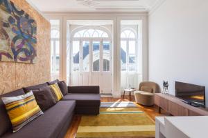 a living room with a couch and a tv at BO - Sá da Bandeira in Porto