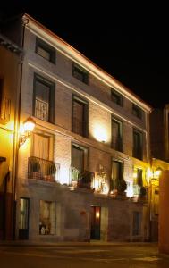 - un bâtiment avec des fenêtres et des balcons la nuit dans l'établissement Hotel Duques de Najera, à Nájera
