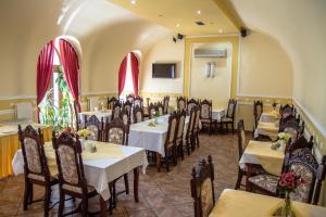 restauracja ze stołami i krzesłami w pokoju w obiekcie Hotel Astoria w mieście Satu Mare