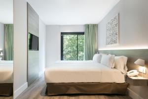 a bedroom with a large bed and a window at Niu Barcelona Hotel in Barcelona