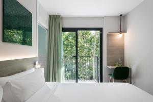 バルセロナにあるニウ バルセロナ ホテルのベッドルーム1室(ベッド1台、大きな窓付)