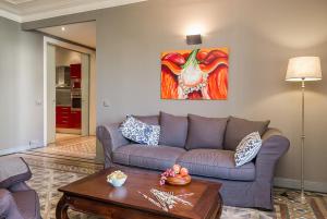a living room with a couch and a painting on the wall at Bcn Paseo De Gracia Rocamora Apartment in Barcelona
