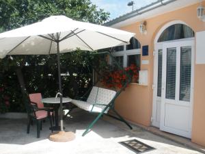 a table and chairs under an umbrella on a patio at Apartment Gogi in Vodice