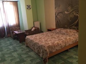 ヴィチャゼヴォにあるDaniil Guest Houseのベッドルーム1室(ベッド1台、椅子、テーブル付)