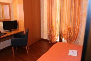 a room with a desk and a chair and a television at Elclaca in Alghero
