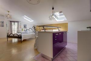 a kitchen with a purple counter in a room with a bed at Apartments Mandarina in Mali Lošinj