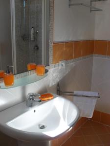 La salle de bains est pourvue d'un lavabo blanc et d'un miroir. dans l'établissement Elclaca, à Alghero