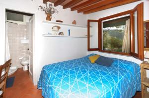 ポルトフェッラーイオにあるIl Melograno - Goelbaのベッドルーム(青いベッド1台付)、バスルーム