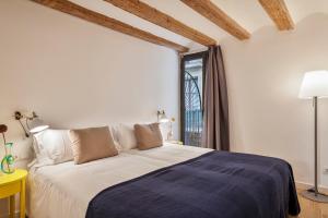 Un dormitorio con una cama grande y una ventana. en Inside Barcelona Apartments Esparteria, en Barcelona