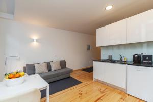 a kitchen and a living room with a couch at BO - Almada in Porto