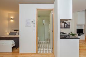 a white apartment with a bedroom and a kitchen at BO - Almada in Porto