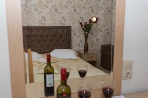 a bedroom with a bed with two glasses of wine at Studios Ristas 2 in Parga