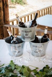 deux seaux de bouteilles de vin et de verres sur une table dans l'établissement El Rincon del Cerrillo, à Cortijo de Arriba