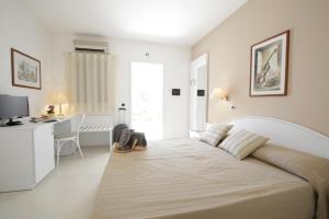 a bedroom with a large bed and a desk at Garden Hotel Ripa in Vieste