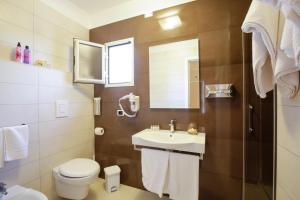 a bathroom with a sink and a toilet and a mirror at Garden Hotel Ripa in Vieste