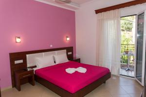 a bedroom with a large bed with a red blanket at Studios Ristas 2 in Parga