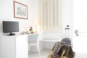 a white desk with a computer and a chair at Garden Hotel Ripa in Vieste