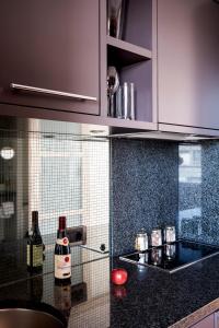 ベルリンにあるThe Mandala Berlin, a Member of Design Hotelsのキッチン(紫色のキャビネット、ワインボトル付)