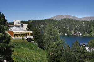 un edificio en una colina junto a un lago en Panorama Hotel Turracher Höhe en Turracher Hohe