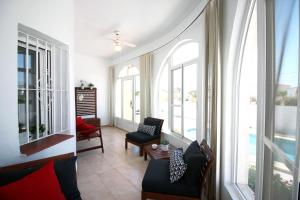 a living room with two chairs and a table and windows at Casa Bruno in Ciudad Quesada