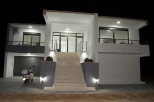 ein weißes Haus mit einem Roller davor geparkt in der Unterkunft Flo Apartments in Ulcinj