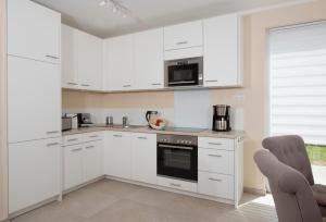a white kitchen with white cabinets and appliances at Ferienhaus Küstensegler in Breege