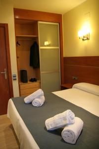 a hotel room with two beds with towels on the bed at Apartaments Aragó565 in Barcelona